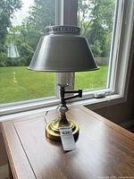 Full view of lamp on table showing mixed metal construction and shade