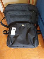Front view of both laptop bags showing size difference and external pockets