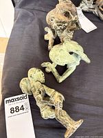 Group of three Dogon bronze sculptures next to lot tag 884