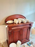 Front view of cherry wood server cabinet with dishware sitting on top (dishware not included)
