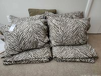 Four zebra stripe pillow shams and two folded matching bedspreads