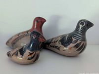 Group shot of three hand-painted clay bird figurines