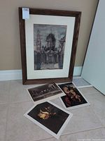 Group shot of framed print and three loose prints on floor
