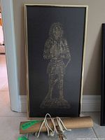 Framed brass rubbing with picture light in front