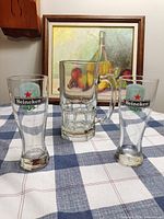 Front view of two Heineken pilsner glasses and large beer mug