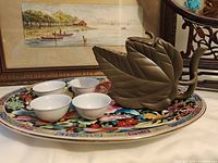 Platter, four teacups and leaf-form teapot displayed together