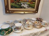 Full set of ten teacups and saucers displayed on table