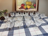 Front view showing full set of 16 cut crystal glasses arranged on table