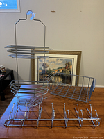 All five chrome organizers grouped: shower caddy, two slide baskets, six-hook rack visible