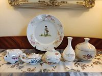 Group shot showing plate, piggy bank, creamer, small lidded bowl, bud vase, large covered dish