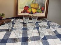 Front view of all eleven cut crystal wine glasses on table