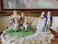 Front view of both porcelain figurines on lace doily