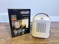 Front view of DeLonghi heater beside box