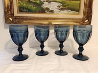 Front view showing all four blue glass goblets