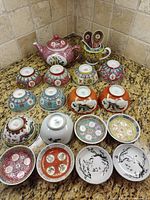 Full set laid out showing teapot, creamer, bowls, saucers