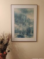 Framed woodland landscape print on wall