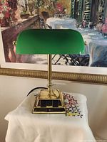 Front view of lamp showing green glass shade, brass base and cord