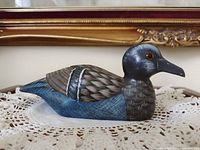 Left side view of wooden duck decoy showing paint finish and glass eye