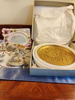 Overview of all three items: boxed plate, figurine, prayer plaque