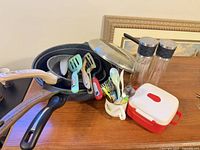 Assorted cookware, utensils, grinders and container displayed