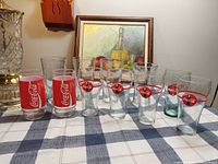Full group of 11 Coca-Cola glasses on table