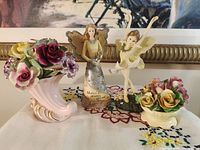 Group shot of all four items: cornucopia vase, floral bowl, angel figurine, ballerina fairy figurine