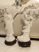 Front view of both porcelain figurines on stands