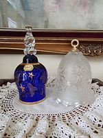 Front view of cobalt blue Bohemia bell and frosted bell on lace cloth