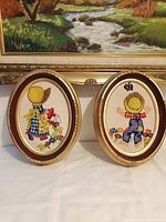 Both framed embroidery pieces side by side