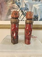 Front view of both hand-carved wood figures displaying overall form, color and pattern