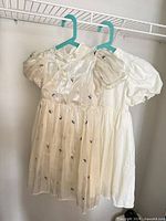 Front view of both ivory dresses hanging