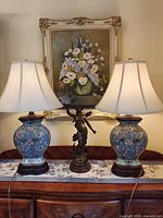 Both matching blue floral cloisonné-style lamps with shades on sideboard