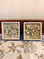Front view of both square floral resin plaques