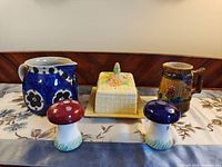 Group shot of jug, butter dish with lid, mushroom shakers, tankard