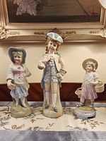 Front view of three porcelain children figurines