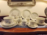 Full set displayed: plates, cups, saucers, sugar bowl, creamer, serving bowls