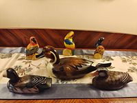 Six wooden bird figurines on runner