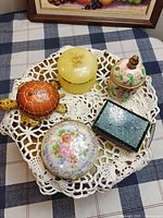 Top view of all five trinket boxes on doily