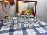 Full set of six clear ribbed beer mugs on table