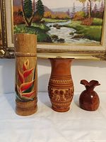 Front view of the three wooden vases showing size and design differences