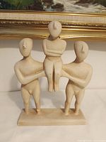 Front view of Greek terracotta sculpture showing three figures and overall form