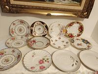 All twelve saucers arranged showing variety of patterns and shapes