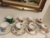 Eight teacup and saucer sets displayed