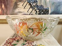Oblique front view of clear crystal bowl on cloth, showing starburst and leaf cuts
