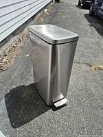 Full left-front view of stainless steel step trash can showing brushed finish and foot pedal