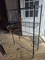 Front view of assembled black wire shelving with four shelves