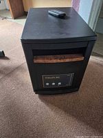 Front view of EdenPURE heater showing wood accent, control panel, remote on top