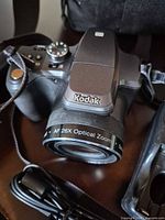 Front view of Kodak bridge camera showing AF 26X Optical Zoom lens and neck strap