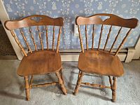 Front view of both wooden Windsor dining chairs