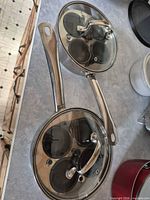 two views of stainless steel egg poacher pan with glass lids showing overall condition